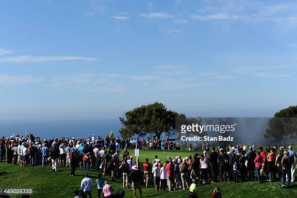 Spectators watch Stewart Cink putt on the 6th green during the third round of the Farmers Insurance Open on Torrey Pines South on January 25, 2014 in...