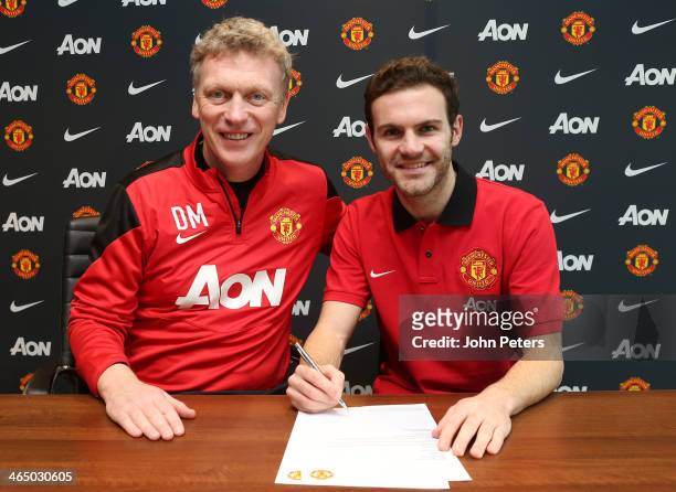 Juan Mata of Manchester United poses with Manchester United Manager David Moyes after signing his contract with the club at Aon Training Complex on...