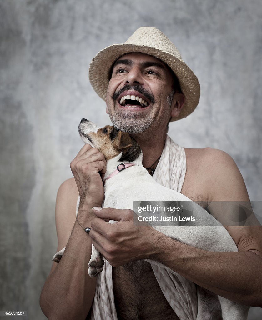 Portrait of man laughing while holding small dog