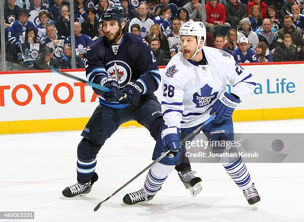 Chris Thorburn of the Winnipeg Jets and Colton Orr of the Toronto Maple Leafs battle for position as they keep an eye on the play during first period...
