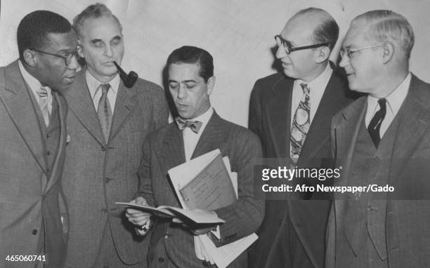 At Foley Square federal courthouse, defense attorneys for 12 American Communists on trial hold a corridor conference, New York, New York, October 14,...