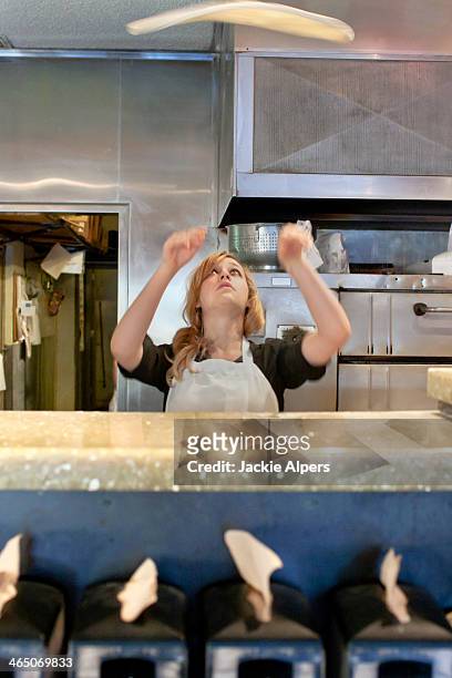 woman tossing pizza dough in the air - pizza toss foto e immagini stock
