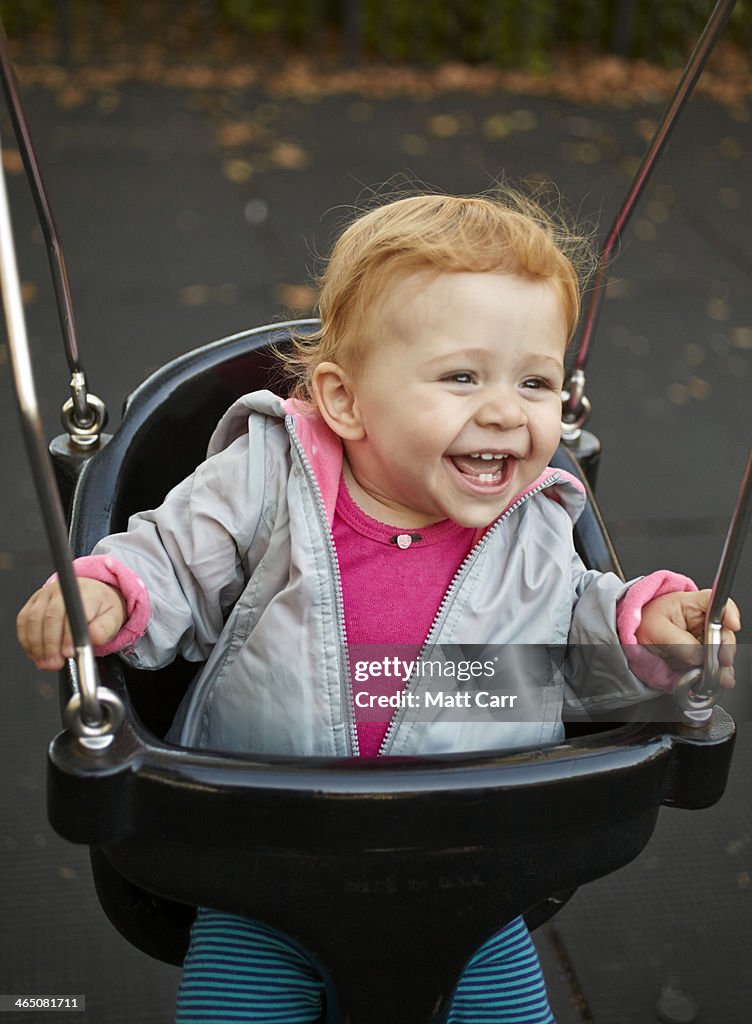 Happy baby girl on swing