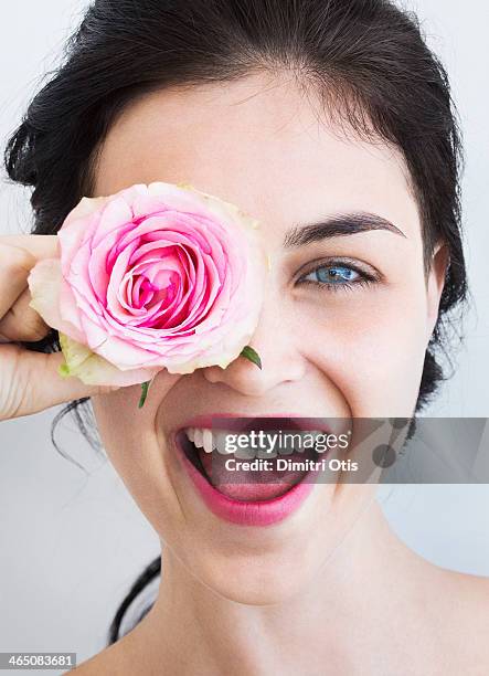 young woman holding rose to her face, laughing - rosa color 個照片及圖片檔