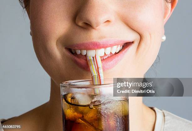 close-up of woman's smiling mouth and soft drink - straw lips stock pictures, royalty-free photos & images