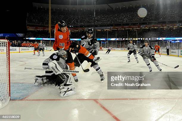 Tim Jackman of the Anaheim Ducks collides with Jonathan Quick and Drew Doughty of the Los Angeles Kings during the 2014 Coors Light NHL Stadium...