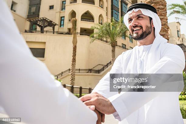 sheikh doing a deal in uae - business hand shake with arabs stock pictures, royalty-free photos & images