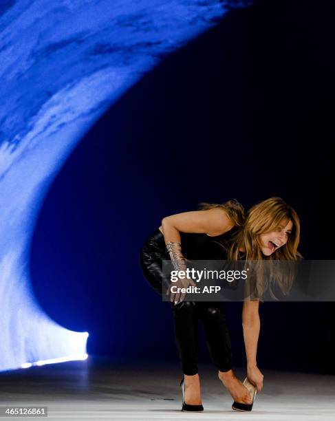 Dutch designer Olcay Gulsen reacts as she loses a shoe on the catwalk at the end of the SuperTrash show at the Amsterdam Fashion Week in Halfweg near...