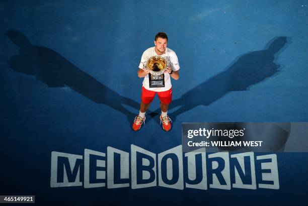 Switzerland's Stanislas Wawrinka poses with the trophy after victory in his mens singles final match against Spain's Rafael Nadal on day fourteen of...