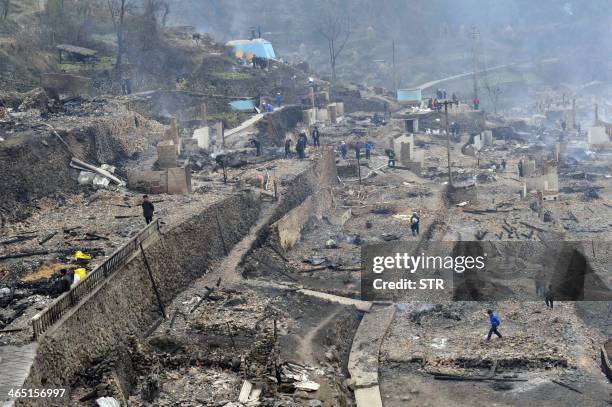 The burnt out remains of Baojing Dong village in Guizhou province is seen on January 26, 2014 after a fire broke out late January 25 that took more...