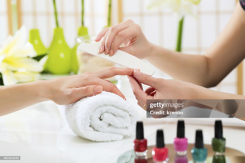 Woman in nail salon receiving manicure