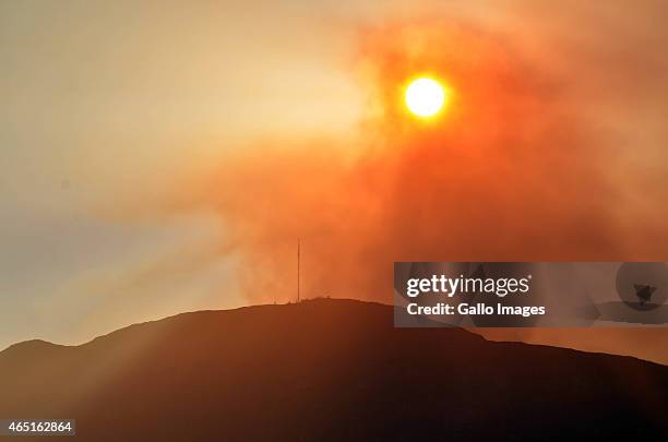 The sun starting to set through the fires smoke. Raging fire on March 2 in Cape Town, South Africa. Fires that broke out in Muizenberg on Sunday have...