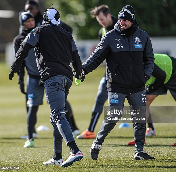 First Team Coach Steve Stone laughs whilst giving Papiss Cisse a bib during a Newcastle United Training session at The Newcastle United Training...