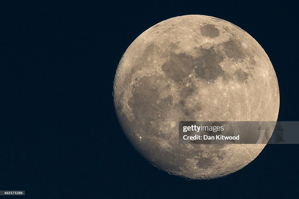 A Plane Is Dwarfed As It Flies Past The Moon