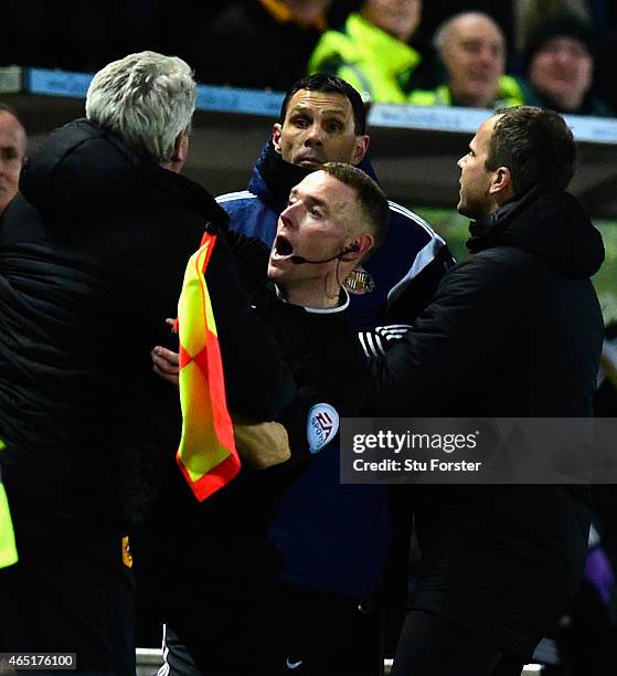 Hull manager Steve Bruce is held back by the assistant referee as he and Sunderland manager Gus Poyet argue after Poyet is sent to the stand during...