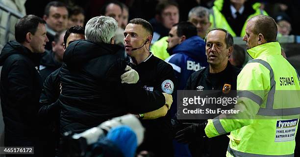 Hull manager Steve Bruce is held back by the assistant referee as Sunderland manager Gus Poyet is sent to the stand during the Barclays Premier...