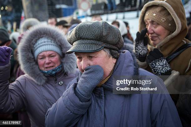 Women mourn the death of Mikhail Zhiznevsky a protester killed during clashes with police on Wednesday, as his body is carried through Independence...