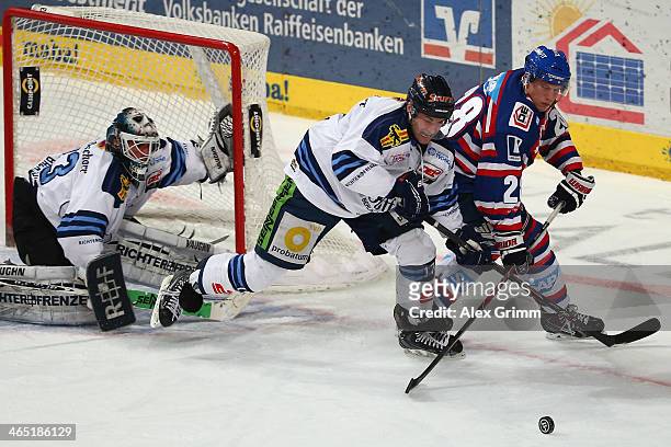 Frank Mauer of Mannheim is challenged by against Florian Ondruschka and goalkeeper Jason Bacashihua of Straubing during the DEL match between Adler...