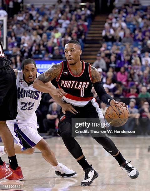 Damian Lillard of the Portland Trail Blazers dribbles past Andre Miller of the Sacramento Kings at Sleep Train Arena on March 1, 2015 in Sacramento,...