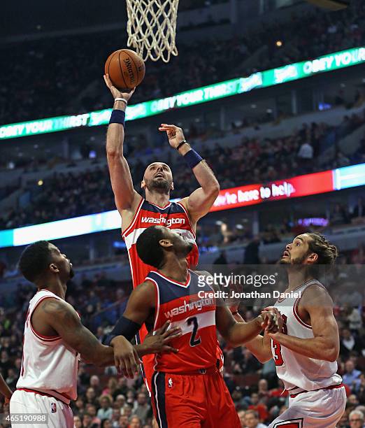 Marcin Gortat of the Washington Wizards shoots over teammate John Wall and Aaron Brooks and Joakim Noah of the Chicago Bulls at the United Center on...