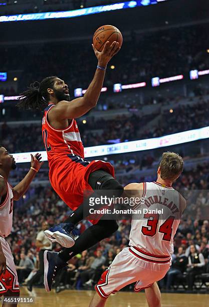 Nene Hilario of the Washington Wizards goes up shot a shot over Mike Dunleavy of the Chicago Bulls at the United Center on March 3, 2015 in Chicago,...