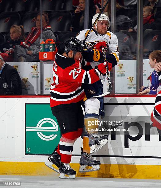 Jordin Tootoo of the New Jersey Devils hits Mattias Ekholm of the Nashville Predators into the boards during the third period at the Prudential...