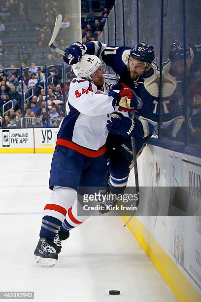 Brooks Orpik of the Washington Capitals checks Nick Foligno of the Columbus Blue Jackets into the glass during the second period on March 3, 2015 at...