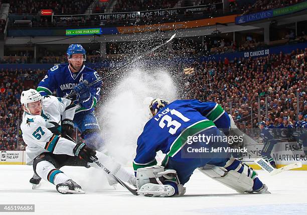 Dan Hamhuis watches Eddie Lack of the Vancouver Canucks make a save on Tommy Wingels of the San Jose Sharks during their NHL game at Rogers Arena...