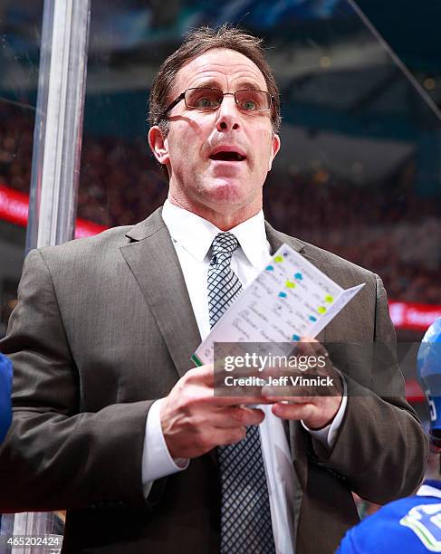 Assistant coach Doug Lidster of the Vancouver Canucks looks on from the bench during their NHL game against the St. Louis Blues at Rogers Arena March...