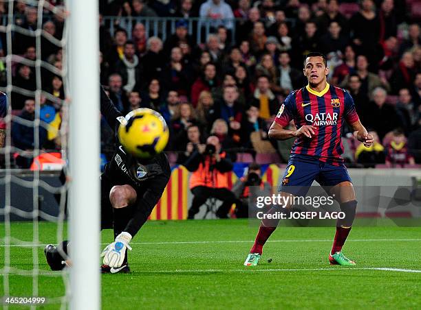 Barcelona's Chilean forward Alexis Sanchez eyes the ball after shooting past Malaga's Argentinian goalkeeper Willy Caballero during the Spanish...