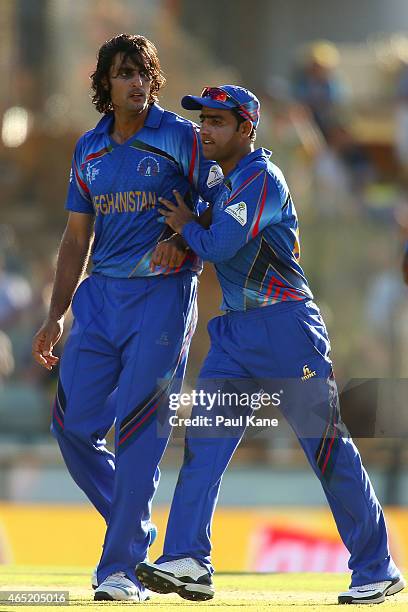 Shahpur Zadran of Afghanistan is congratulated by Usman Ghani after dismissing David Warner of Australia during the 2015 ICC Cricket World Cup match...