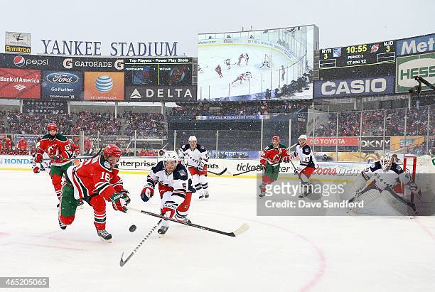 Jacob Josefson of the New Jersey Devils and Dan Girardi of the New York Rangers vie for the puck in the second period during the 2014 Coors Light NHL...