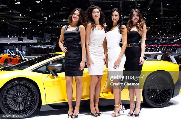 Models pose next to the new Lamborghini Aventador SV model car during the 85th Geneva International Motor Show on March 4, 2015 in Geneva,...