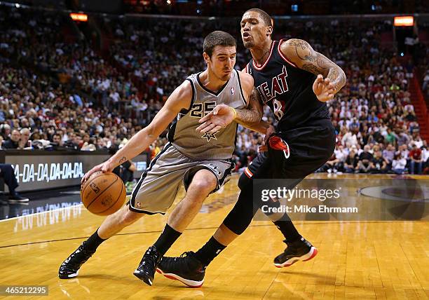 Nando de Colo of the San Antonio Spurs drives around Michael Beasley of the Miami Heat during a game at American Airlines Arena on January 26, 2014...