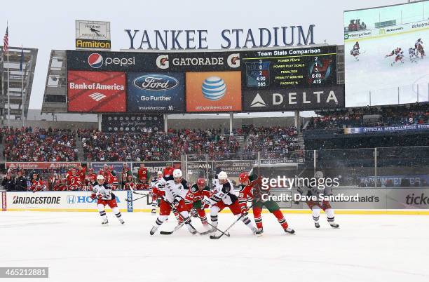 Brad Richards and John Moore of the New York Rangers vie for the puck with Ryan Carter and Steve Bernier of the New Jersey Devils in the high slot...