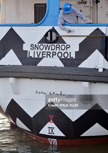 Painter works on the Mersey Ferry, 'Snowdrop' in a dock in Birkenhead, north west England on March 4, 2015. The ferry has been transformed from its...