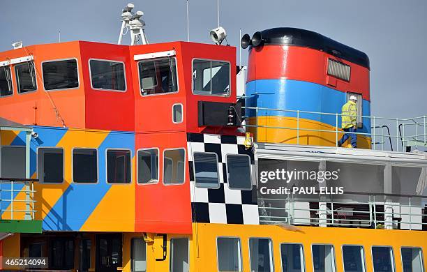 Painter works on the Mersey Ferry, 'Snowdrop' in a dock in Birkenhead, north west England on March 4, 2015. The ferry has been transformed from its...