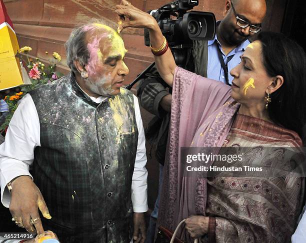 Bollywood actor and BJP MP Hema Malini smear color on forehead of BJP MP Jagdambika Pal as part of Holi celebration at Parliament during budget...