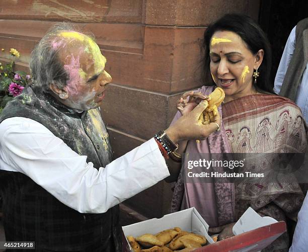 Jagdambika Pal offer Ghujia sweet after playing Holi with film actress and BJP MP from Mathura Hema Malini at Parliament during budget session on...