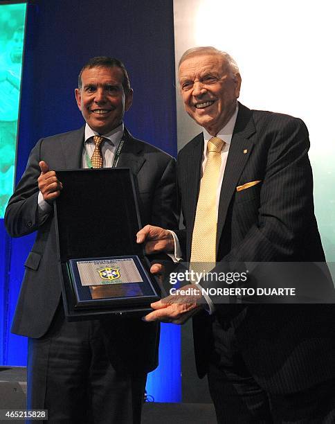 Brazil's football confederation president, Jose Maria Marin gives a plaque to the president of the South American confederation CONMEBOL, Juan Angel...