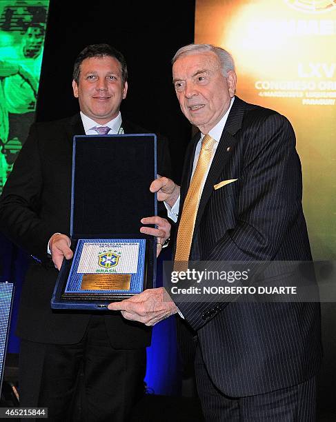Brazil's football confederation president, Jose Maria Marin gives a plaque to the president of the Paraguayan football federation, Alejandro...