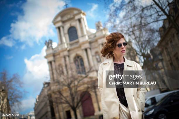 Model Leonore Masson poses outside Dries Van Noten 2015-2016 fall/winter ready-to-wear collection fashion show on March 4, 2015 in Paris. AFP PHOTO /...