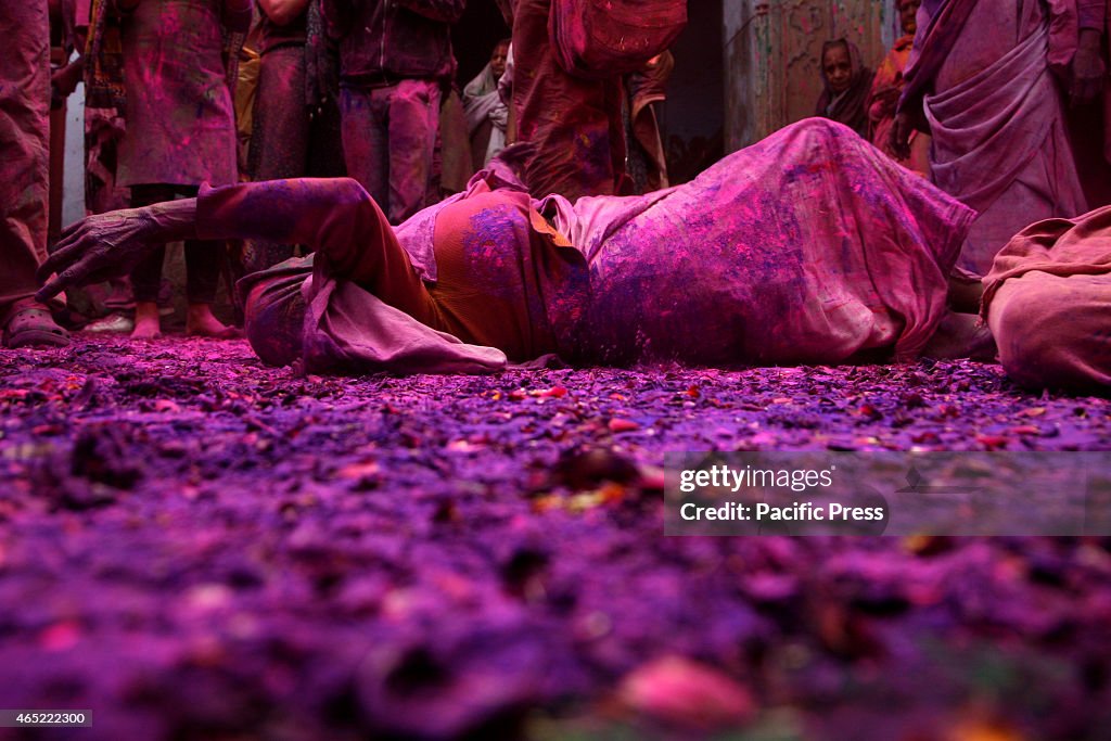 Hindu widows play colored powder as a part of Holi...