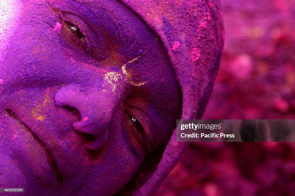 Hindu widows play colored powder as a part of Holi...