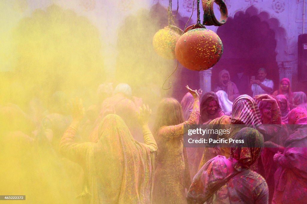 Hindu widows play colored powder as a part of Holi...