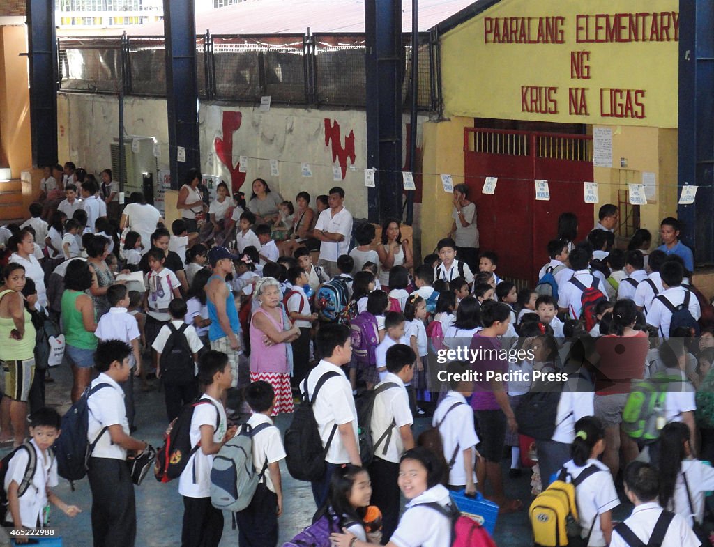 Filipino elementary students fall in line at the covered...