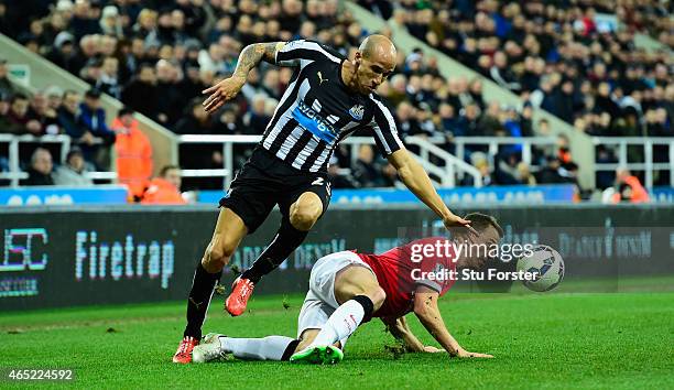 Manchester United player Jonny Evans challenges Gabriel Obertan of Newcastle during the Barclays Premier League match between Newcastle United and...