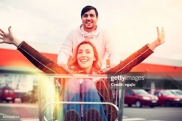 jovem casal de carro carrinho de compras ao ar livre. - drive happy - fotografias e filmes do acervo