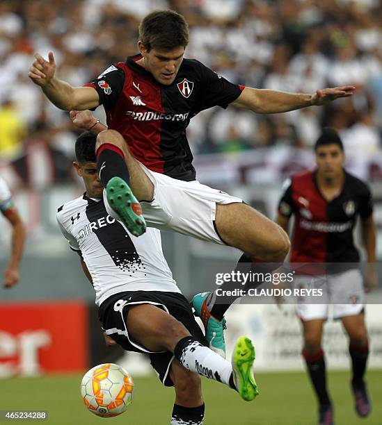 Mexico's Atlas' player Walter Kannemann vies for the ball with Chile's Colo Colo's Esteban Pavez during their Copa Libertadores football match at the...