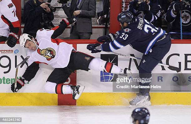 Dustin Byfuglien of the Winnipeg Jets takes down David Legwand of the Ottawa Senators in first-period action in an NHL game at the MTS Centre on...